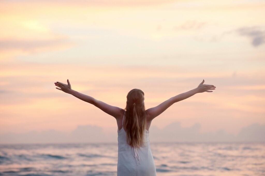 Grateful woman by the sea - gratitude will improve your life in ways you can't even imagine